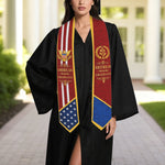 Graduate wearing a black gown with a colorful graduation stole outdoors.